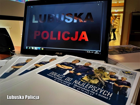 Monitor z napisem Lubuska Policja i ulotki promujące zawód policjanta