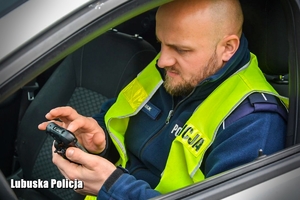 Policjant sprawdza dane kierowców w systemie