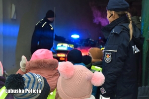 Dzieci z policjantami oglądają pojazdy policyjne