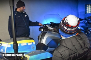 Policjant pokazuje policyjny motocykl