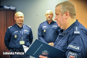 policjant odczytuje list gratulacyjny