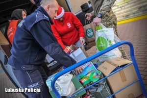 Policjant wkłada prezenty do busa.