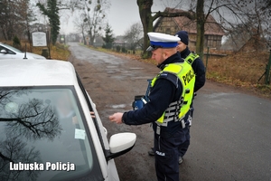 Policjant bierze dokumenty od kierowcy