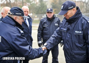 Komendant Wojewódzki Policji wita się z policjantem.