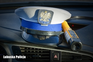 Czapka policyjna oraz urządzenie do sprawdzania trzeźwości na desce rozdzielczej radiowozu
