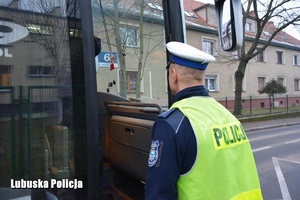 policjant wchodzi do autokaru