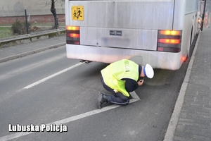 policjant kontroluje stan techniczny autokaru