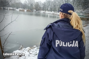 policjantka obserwuje zamarznięte jezioro