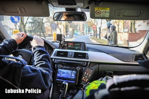 Policjanci drogówki jadący radiowozem podczas patrolu.