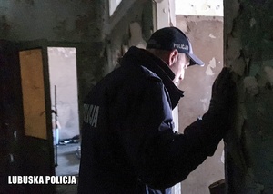 Policjant sprawdza miejsce potencjalnego przebywania osób bezdomnych.