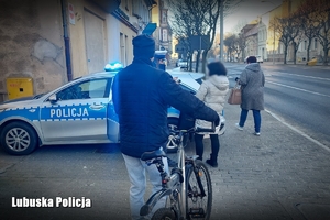 Policjantka przeprowadza rozmowę z pieszymi i rowerzystą