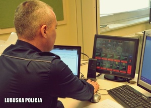 Dyżurny Policji podczas pracy przed monitorem.
