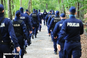Policjanci oddziałów prewencji Policji podczas poszukiwań zaginionego w lesie.
