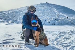 Policyjny kontrterrorysta z psem służbowym na tle góry Śnieżka.