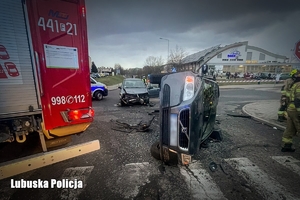Wóz strażacki i pojazd na boku po wypadku