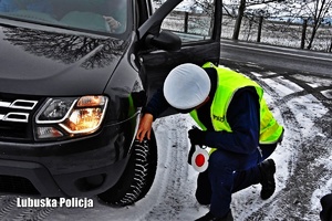 Policjanci ruchu drogowego sprawdza stan opon kontrolowanego samochodu