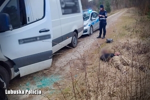 policjantka pilnuje zatrzymanego kierowcę leżącego na ziemi