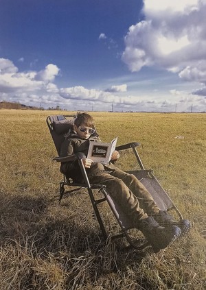 Chłopiec na leżaku z książką