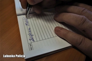 policjant pisze w notatniku