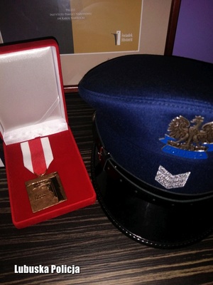 Medal od  Instytutu Pamięci Narodowej dla policjanta oraz czapka