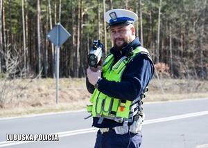 Policjant drogówki kontroluje prędkość jadących pojazdów.