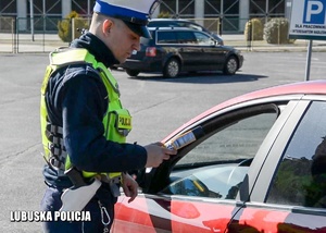 Policjant drogówki przystępuje do kontroli trzeźwości kierowcy.
