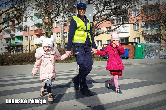 Policjantka przeprowadza dziewczynki przez przejście