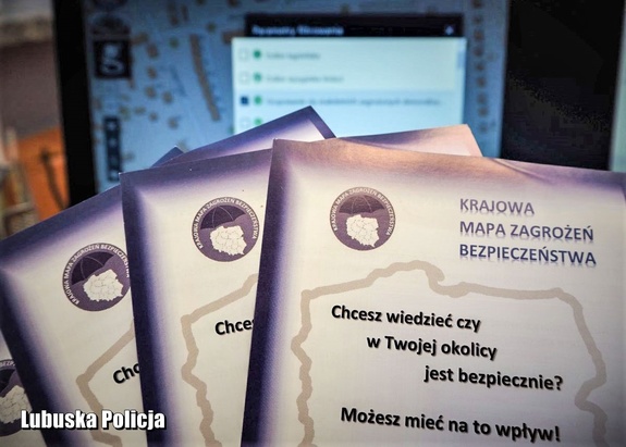 ulotki informacyjne i laptop w tle