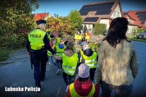 Policjantka prowadzi dzieci przez przejście dla pieszych