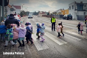 Policjantka pomaga dzieciom przejść przez jezdnię