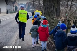 Policjant prowadzi dzieci