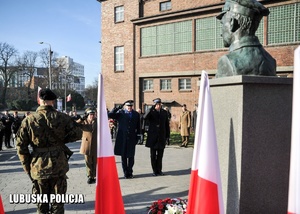 Oddanie honorów przed funkcjonariuszy służb mundurowych przed pomnikiem.