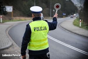 Policjant drogówki zatrzymuje pojazd do kontroli drogowej.