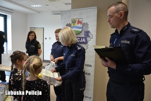 policjanci wręczają nagrody dzieciom