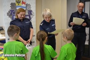 policjanci wręczają nagrody dzieciom