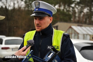 Policjant drogówki udziela wywiadu do radia.