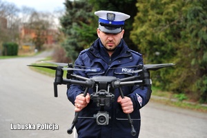 Policjant drogówki podczas uruchomienia drona powietrznego.