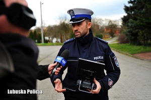 Policjant drogówki - operator drona udziela wywiadu do telewizji.