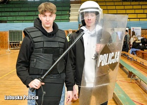 Uczniowie przymierzają umundurowanie policyjne.