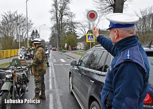 Policjant drogówki daj znak motocyklistom.
