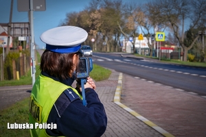 Policjantka podczas pomiaru prędkości jadących pojazdów.