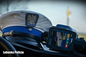 Policyjna czapka obok urządzenia do pomiaru prędkości.