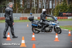 policjant na motocyklu jedzie po torze obok instruktora