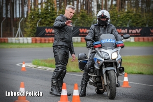 instruktor rozmawia z policjantem na motocyklu