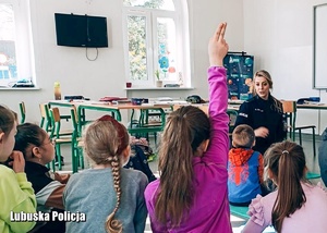 Dzieci z policjantką podczas spotkania profilaktycznego w szkole.