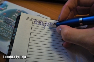 policjant pisze w notatniku