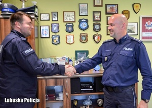 Policjant podaje rękę komendantowi Policji.