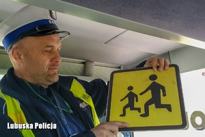 policjant sprawdza tabliczkę informacyjną