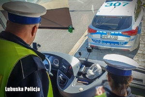 policjantka i policjant rozmawiają z kierowcą autokaru