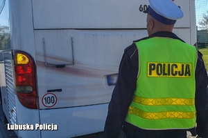 policjant sprawdza stan oświetlenia autokaru